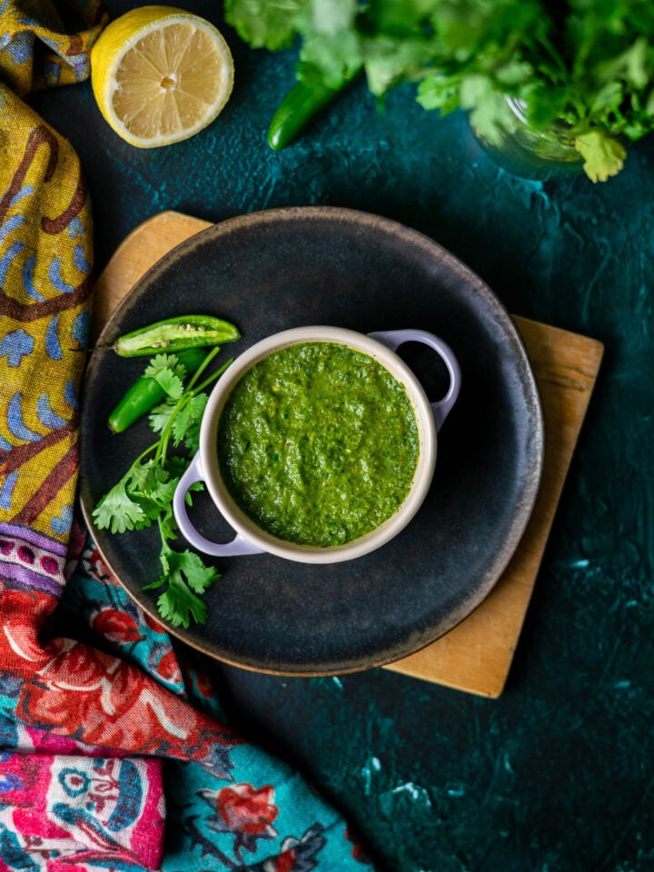 Cilantro Mint Chutney Overhead in Le Creuset Cocette with CIlantro and Serrano Peppers and Half a Lemon with Cilantro