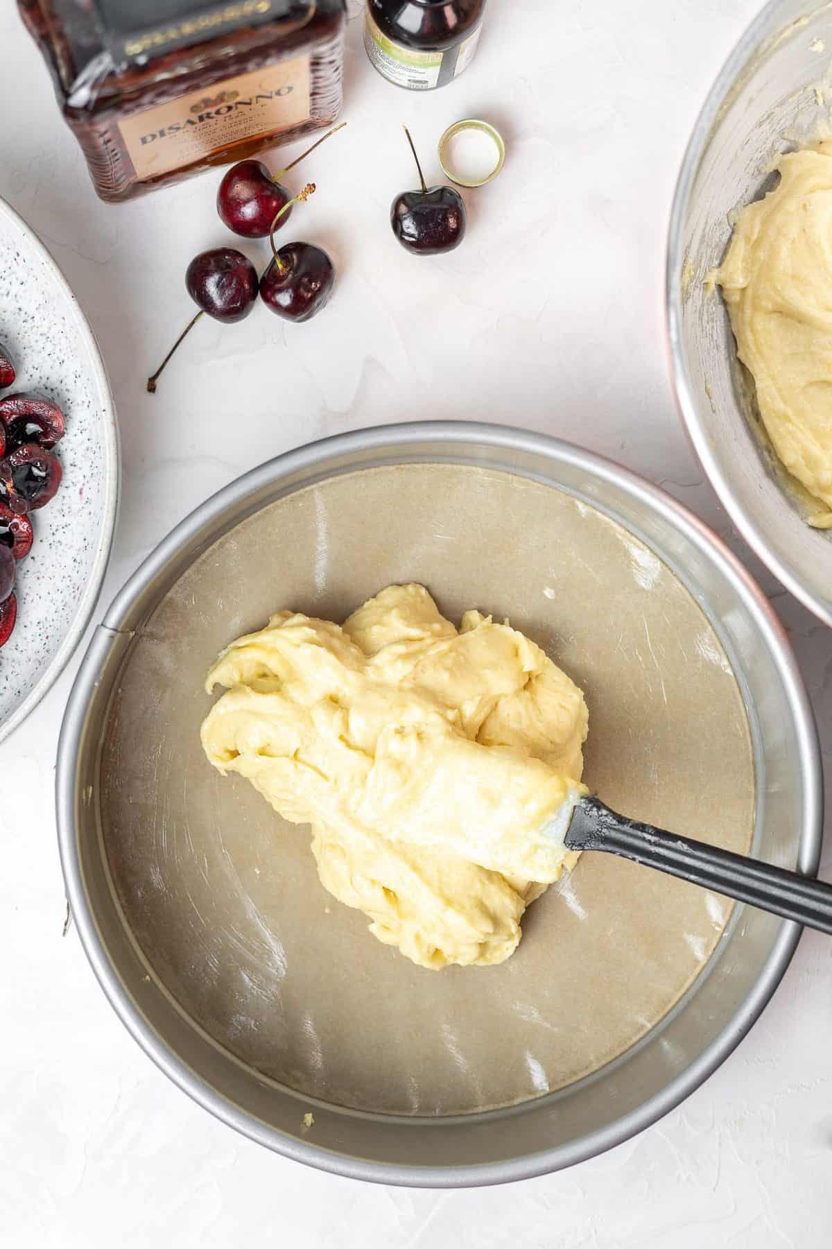 almond cake batter spread in a springform pan with a rubber spatula