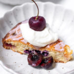 amaretto cherry almond cake in bowl with whipped cream and cherries