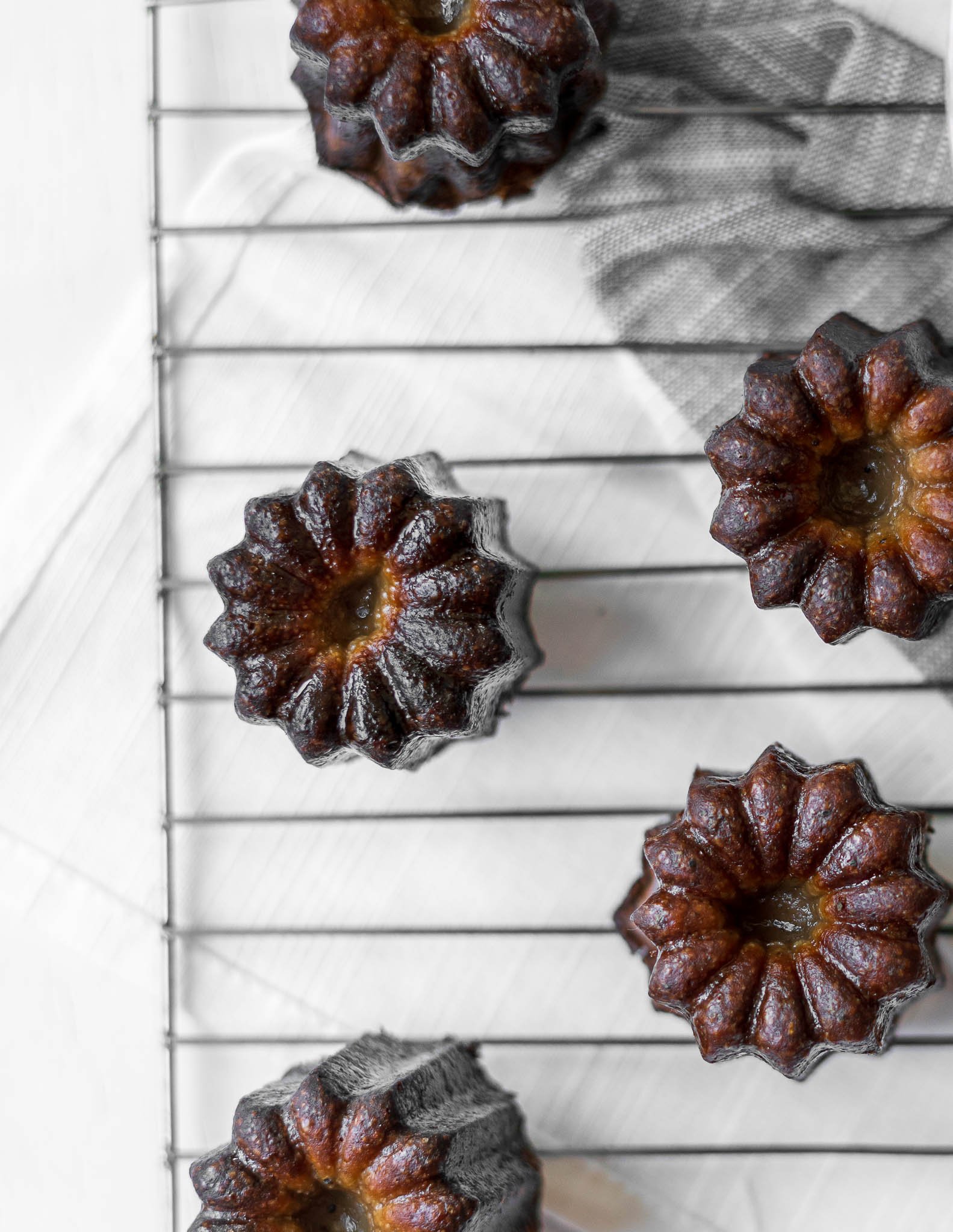 Masala Chai Canelés on a cooling rack with perfect caramelized crust