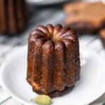 Masala Chai Canelés in a white shallow bowl with a cardamom pod