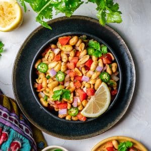 Peanut chaat in black bowl with lemon and cilantro