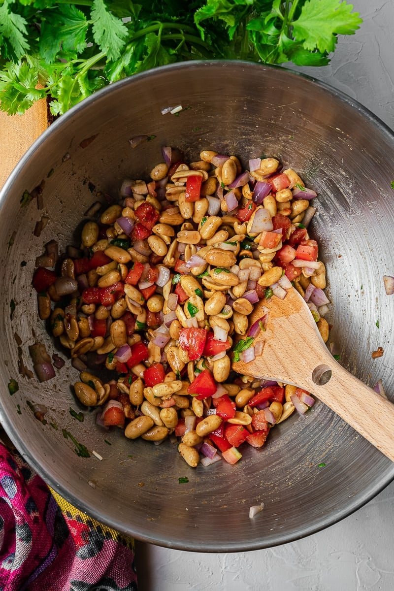 peanut chaat fully mixed in a bowl with a wooden spoon and cilantro