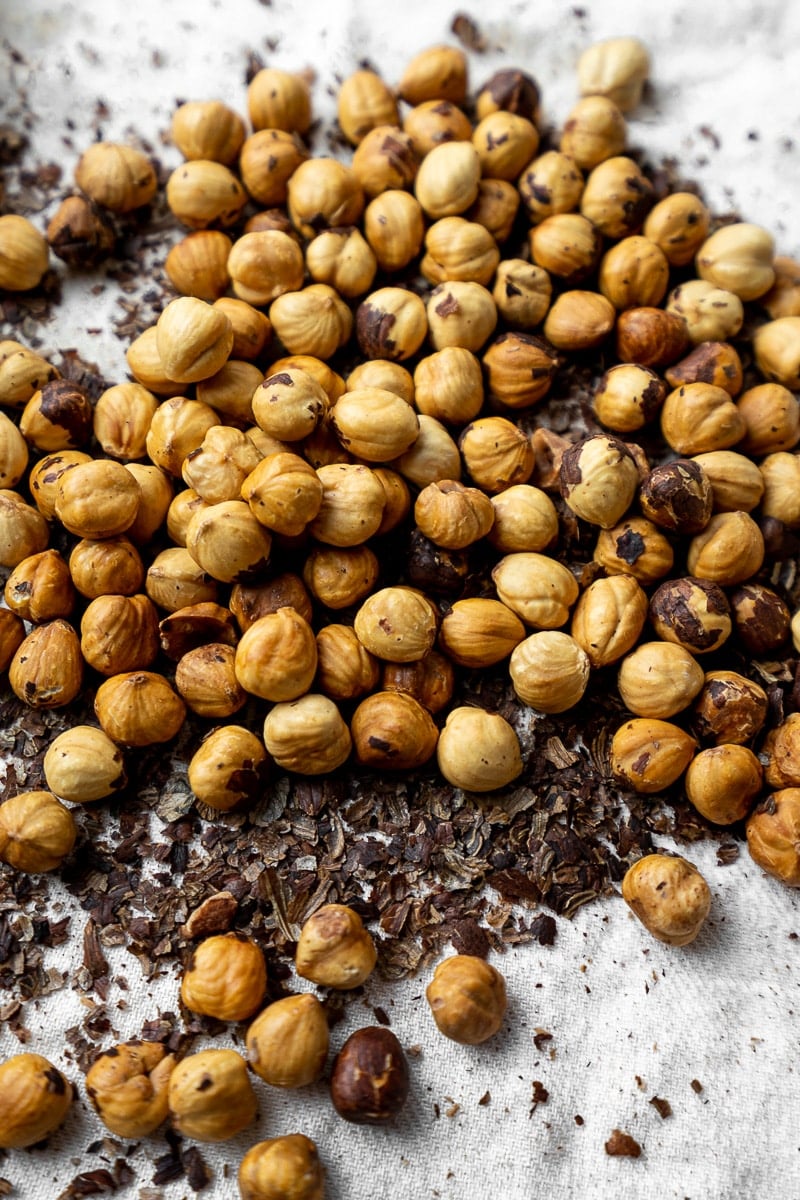 Skinless roasted hazelnuts in pile on towel with skin rubbed off