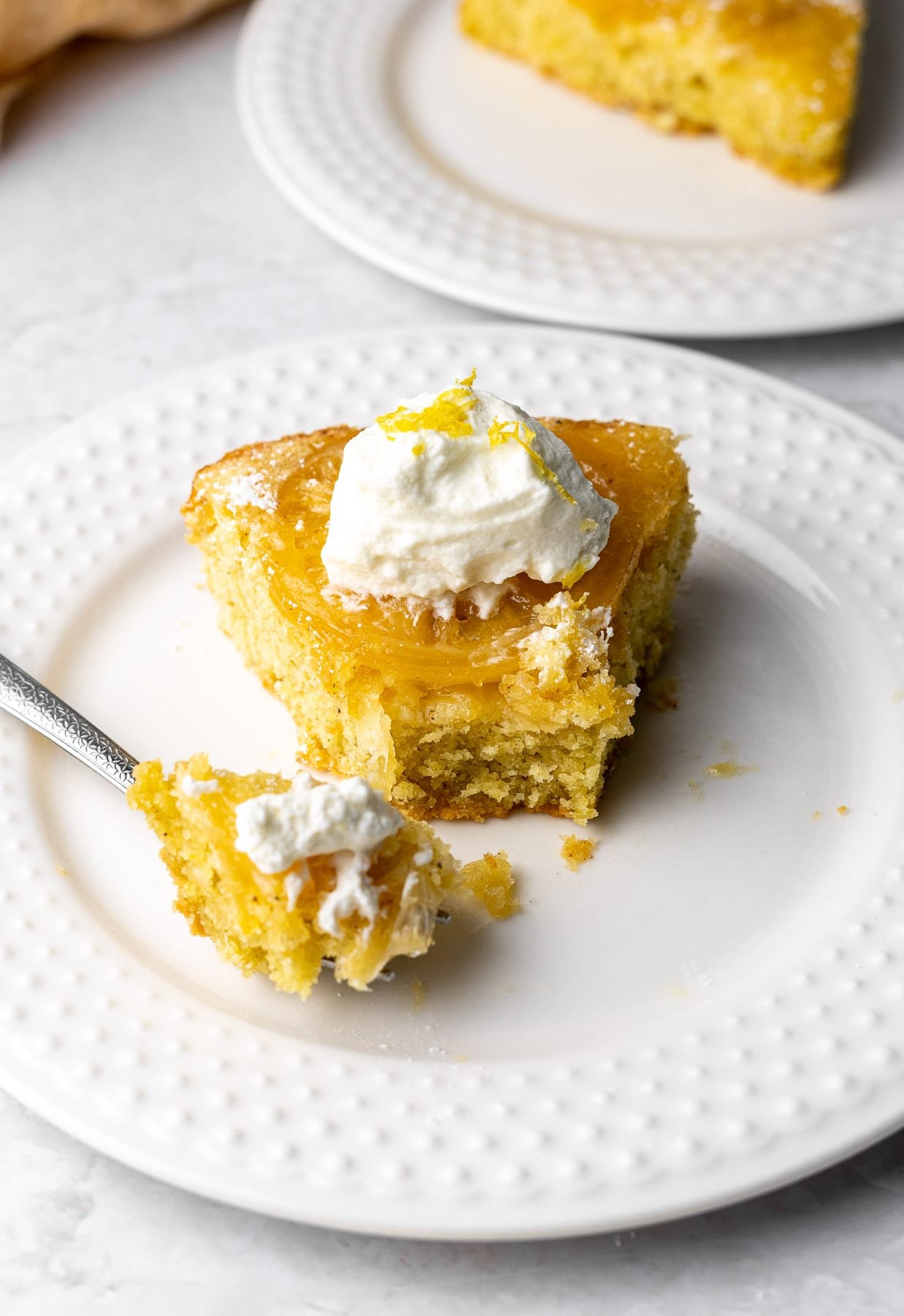 A Bite of Cardamom Lemon Olive Oil Cake with a piece on a cake fork