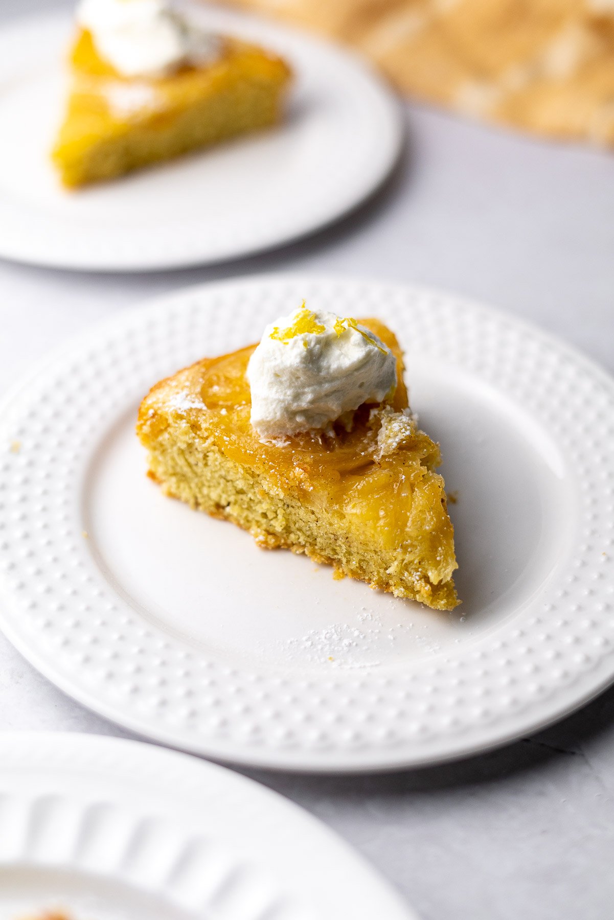 two slices of lemon cardamom olive oil cake with whipped cream