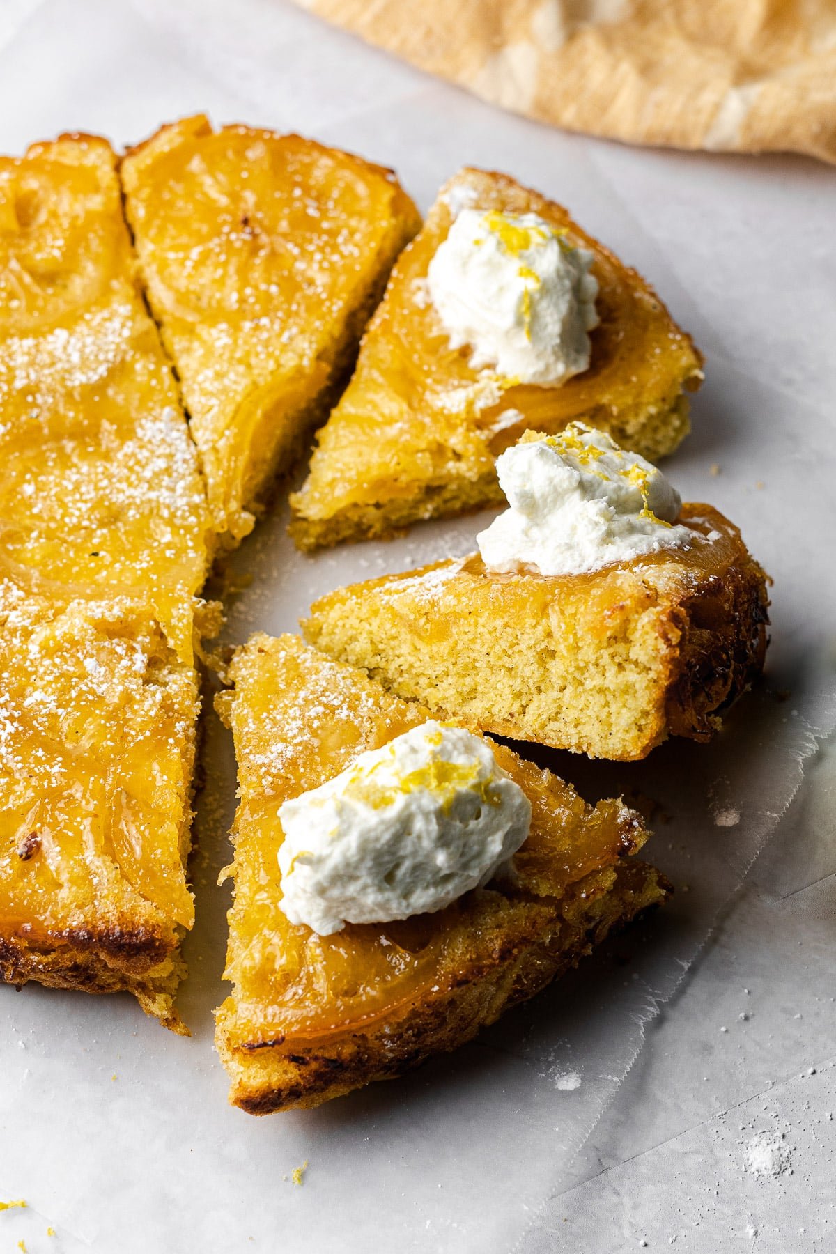 sliced lemon cardamom olive oil cake with a slice perched upwards to show moist cake