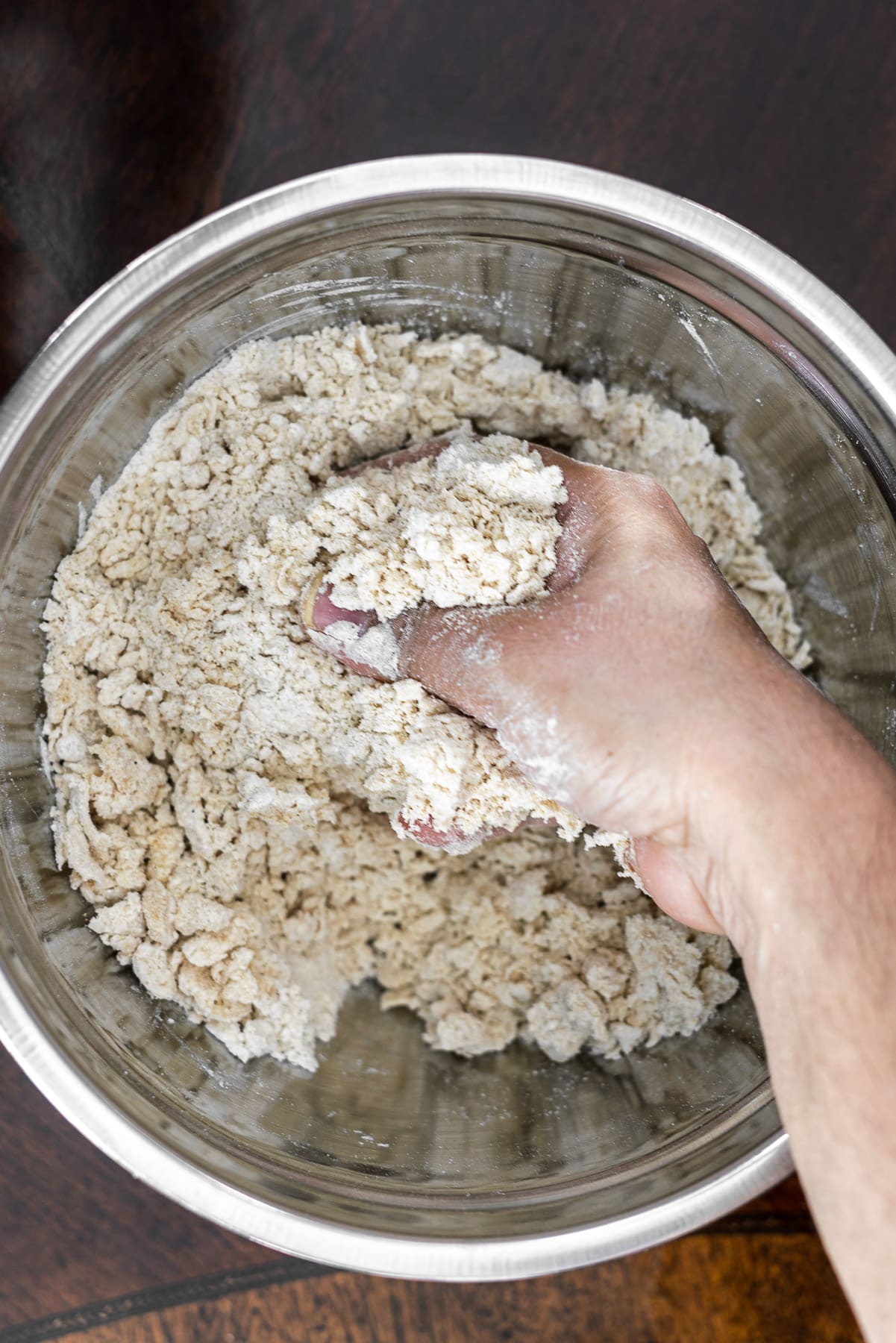 A hand working with shaggy dough