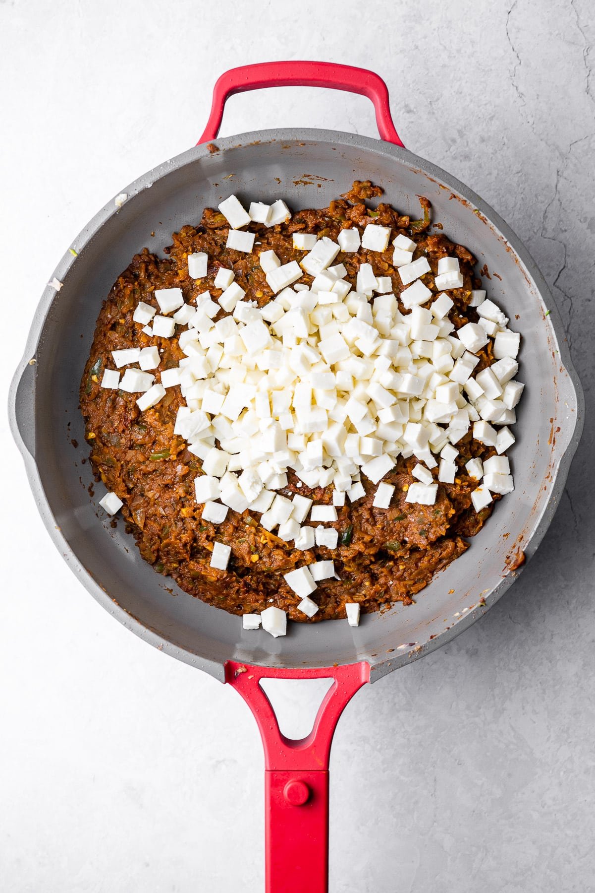 masala and veggie filling with diced paneer in a red always pan