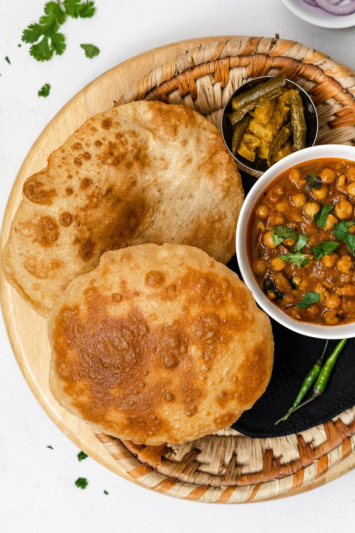 two fried bhature with chole and achaar