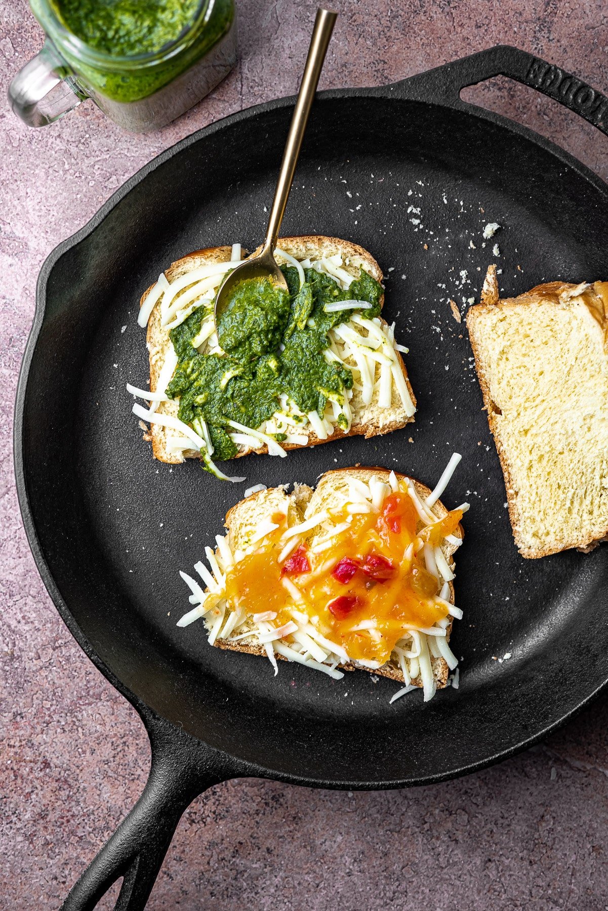 Sliced Bread topped with shredded mozzarella, cilantro mint/mango chutney, chaat masala, and more mozzarella in a cast iron