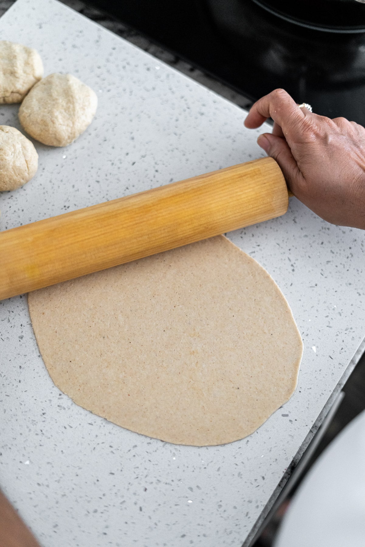 Rolling out bhature dough with a rolling pin