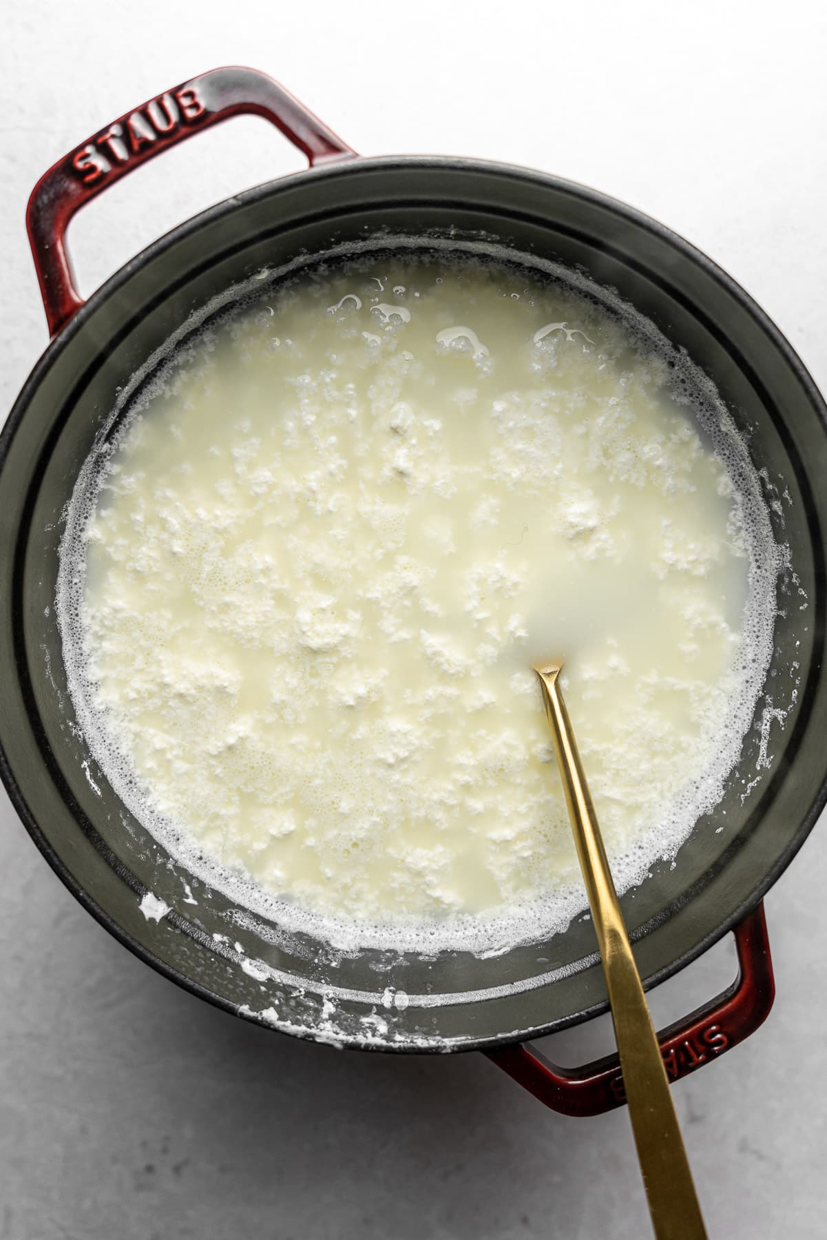 milk Curds and Whey Separated in a staub pot