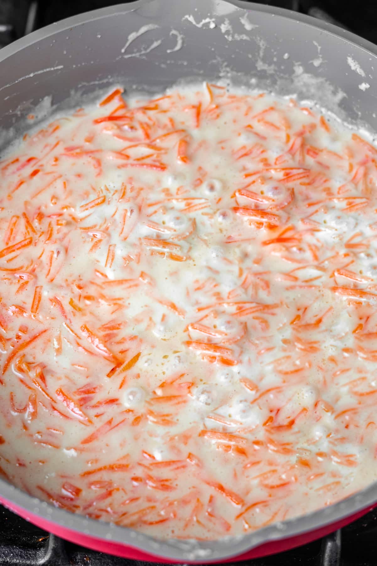 shredded carrots boiling in hot milk with ghee
