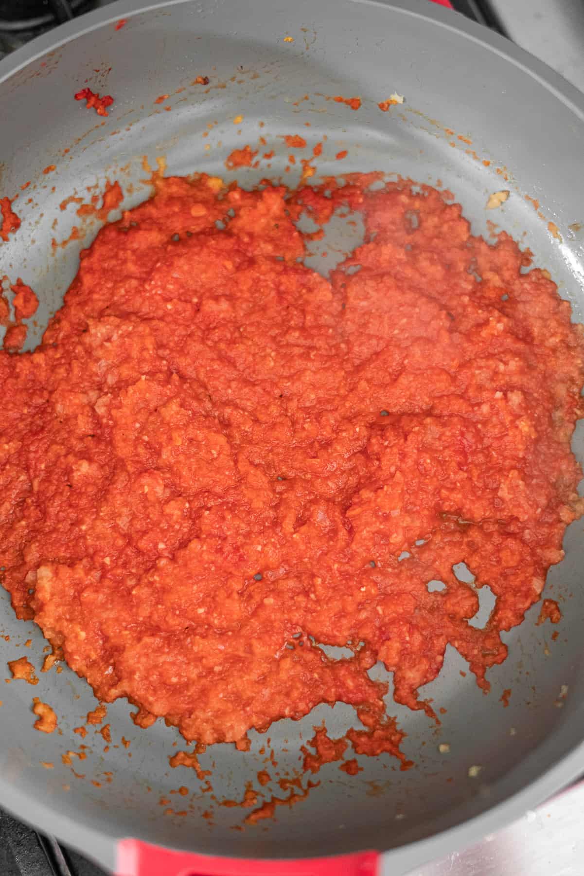 the onions, ginger garlic paste, and tomato paste, and masalas mixed together in a pan