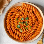 Colonne Pompei pasta covered in butter masala sauce in a pasta bowl with a gold fork