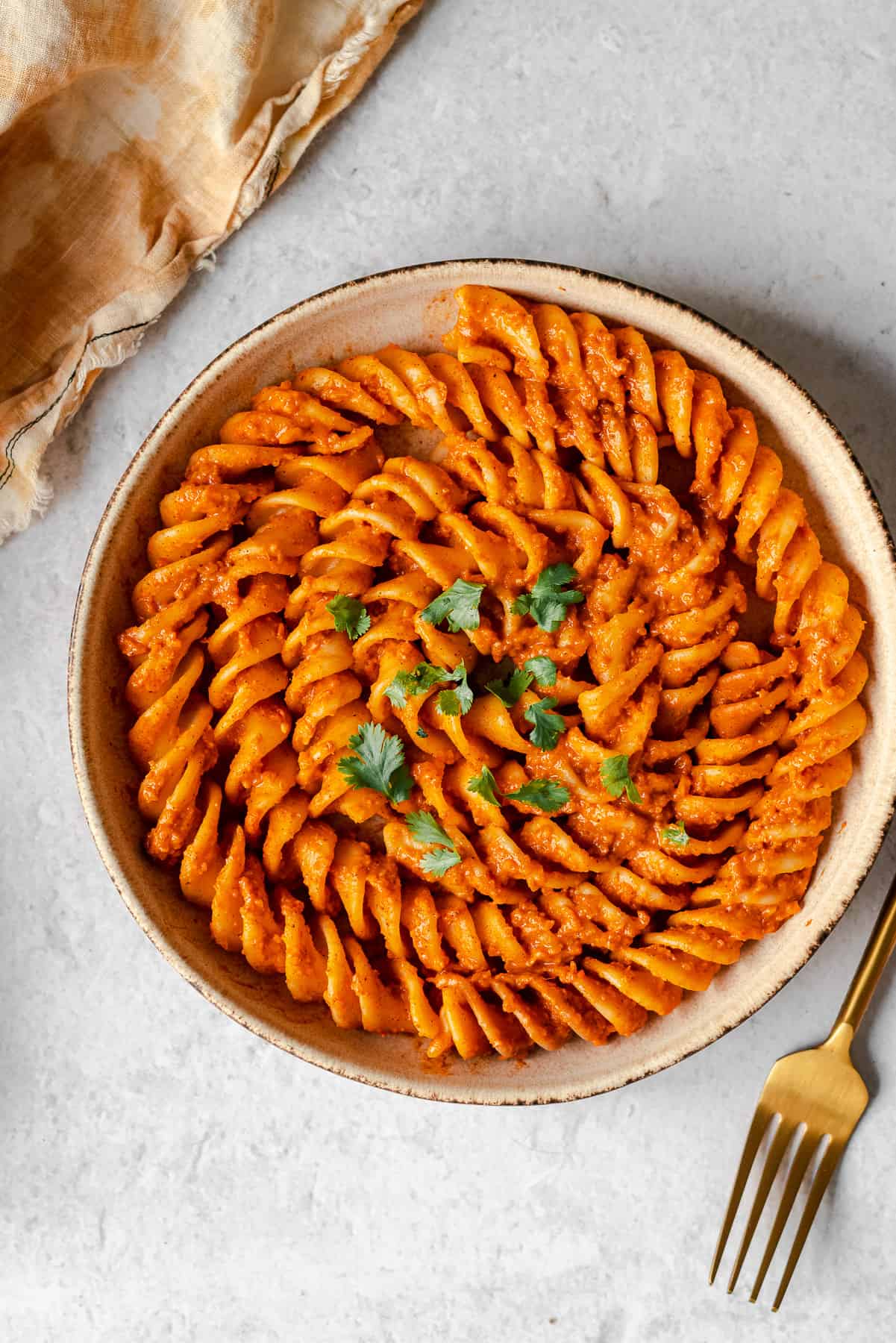 Colonne Pompei pasta covered in butter masala sauce in a pasta bowl with a gold fork