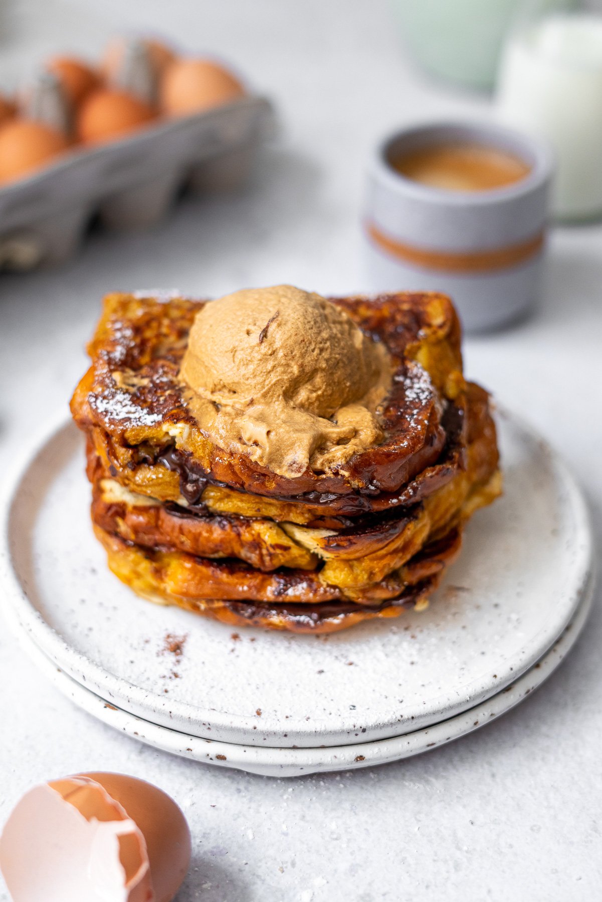 stacked chocolate stuffed brioche french toast with a dollop of coffee whipped cream on top