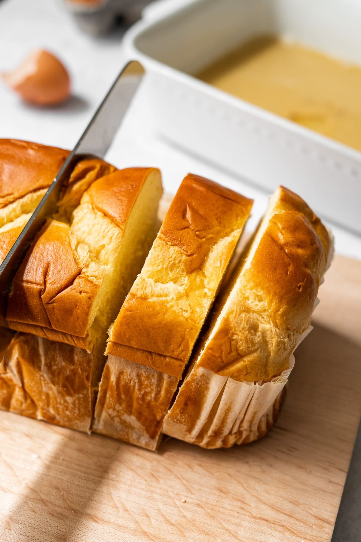 cutting thick cut slices from a brioche bread loaf