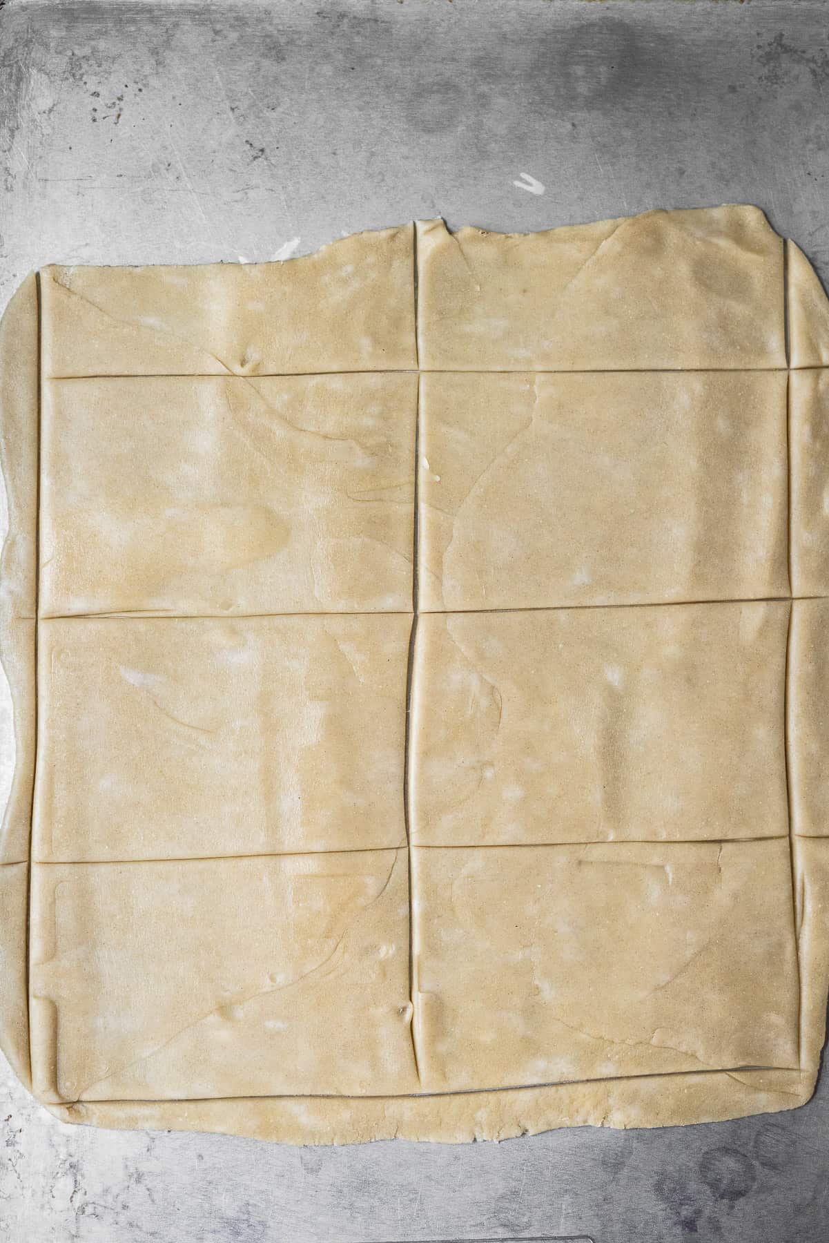 cutting out rectangles in pie dough on a sheet tray