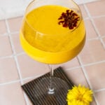 Mango Lassi with a marigold in a spritz glass on a coaster