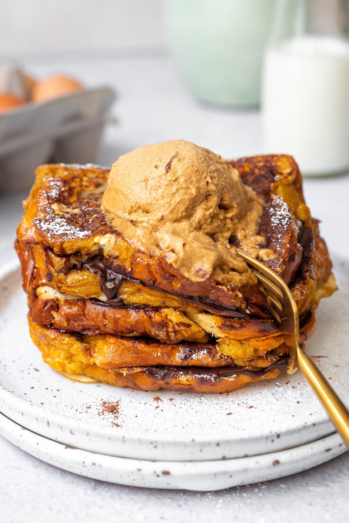 golden spoon digging into chocolate stuffed french toast with whipped coffee cream