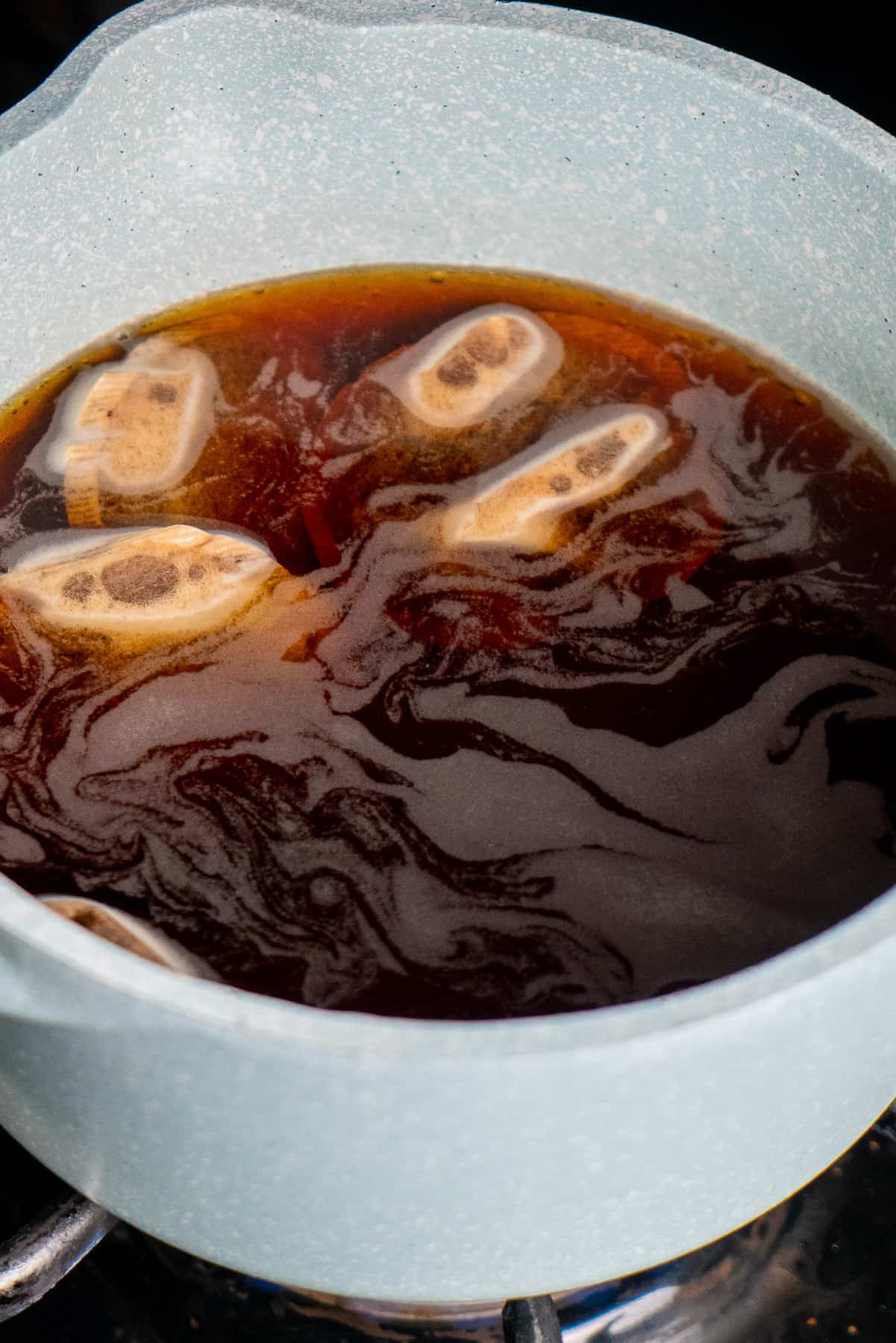 boiling black tea in water in a pot