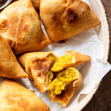 a close up of the paneer aloo samosas ripped open