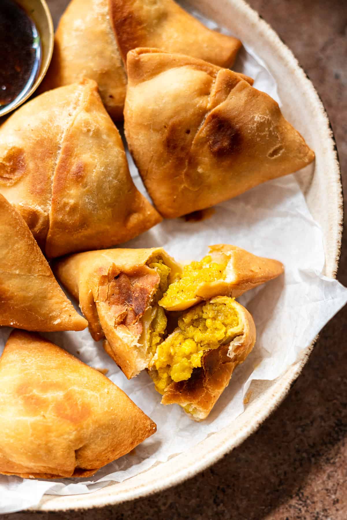 a close up of the paneer aloo samosas ripped open