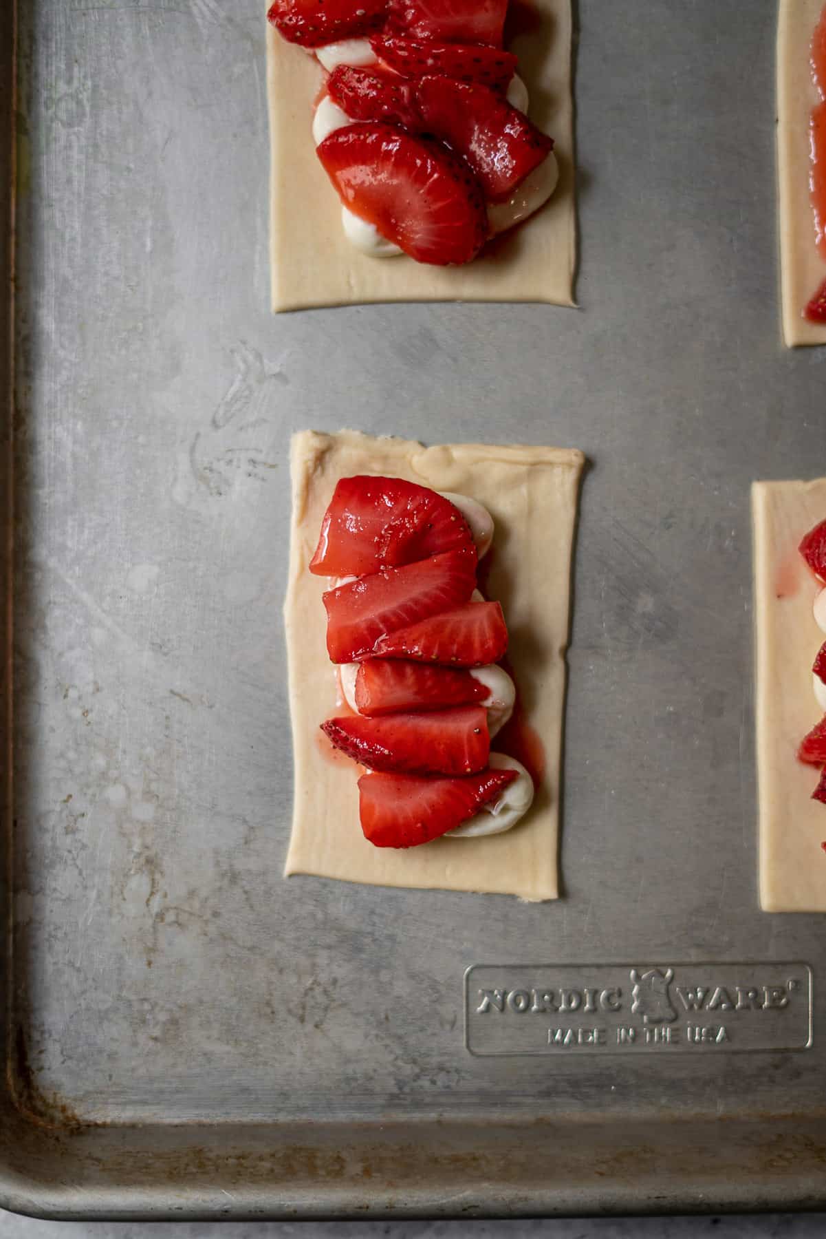 jammy strawberries laid over cream cheese on a puff pastry