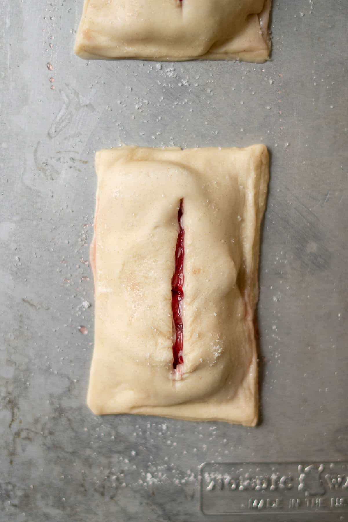 puff pastry sealed with a top layer with a slit down the middle revealing strawberries