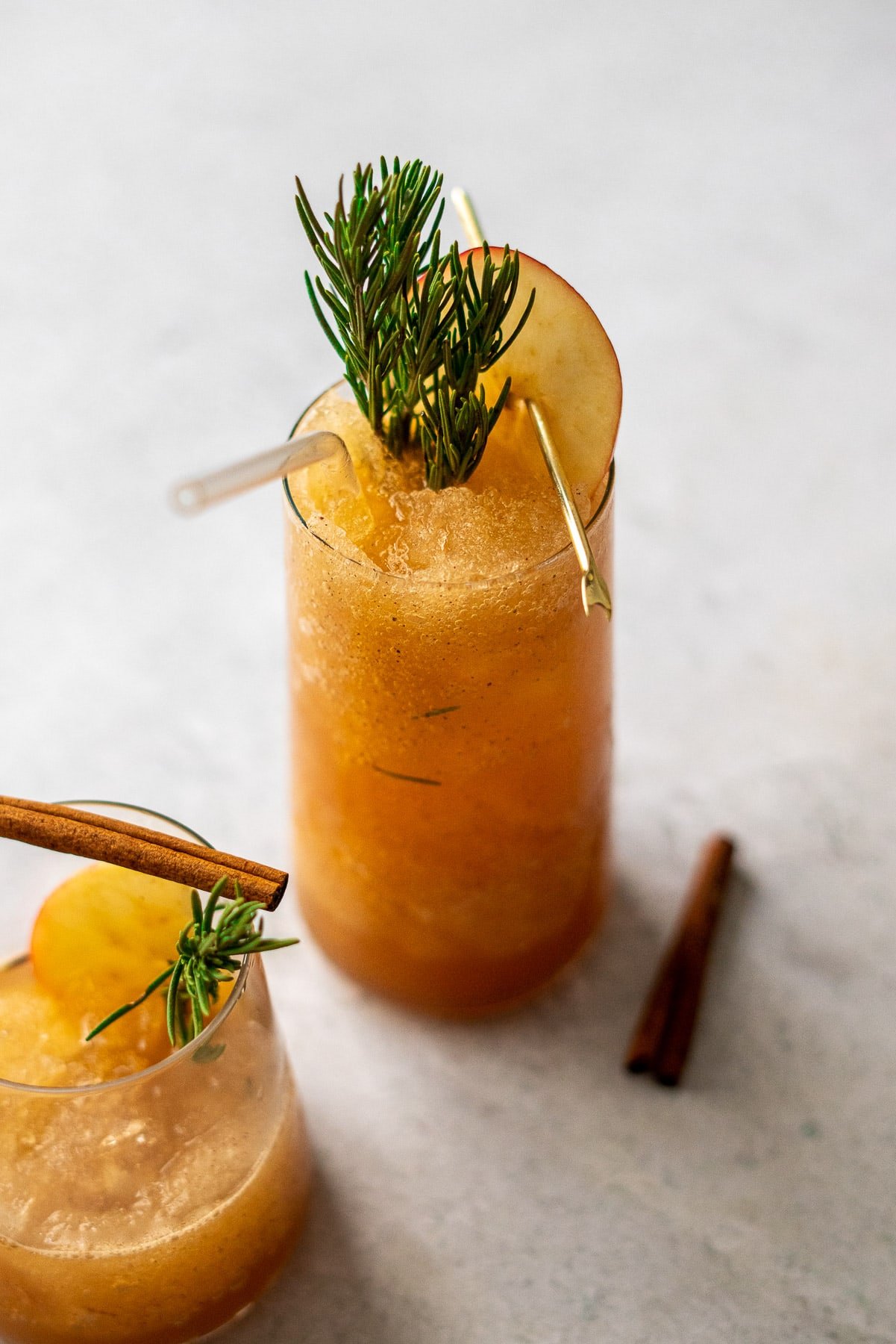 full cup of apple cider slushies with cinnamon sticks