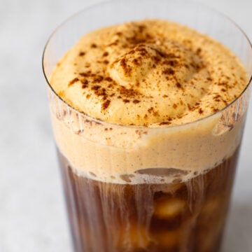 cup with iced coffee and pumpkin cream cold foam on top