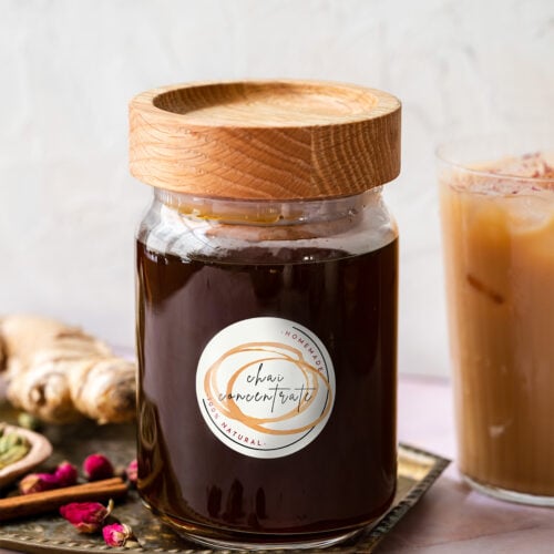 bottle of chai concentrate with a wood lid on a brass platter
