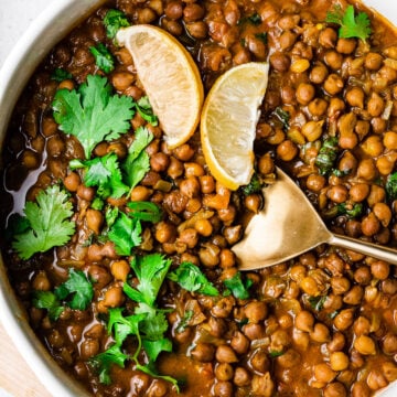 kala chana masala in a serving bowl with a gold serving spoon