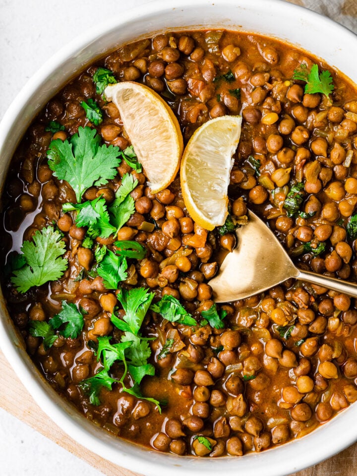 kala chana masala in a serving bowl with a gold serving spoon