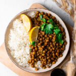 kala chana in a bowl with rice and lemon slices