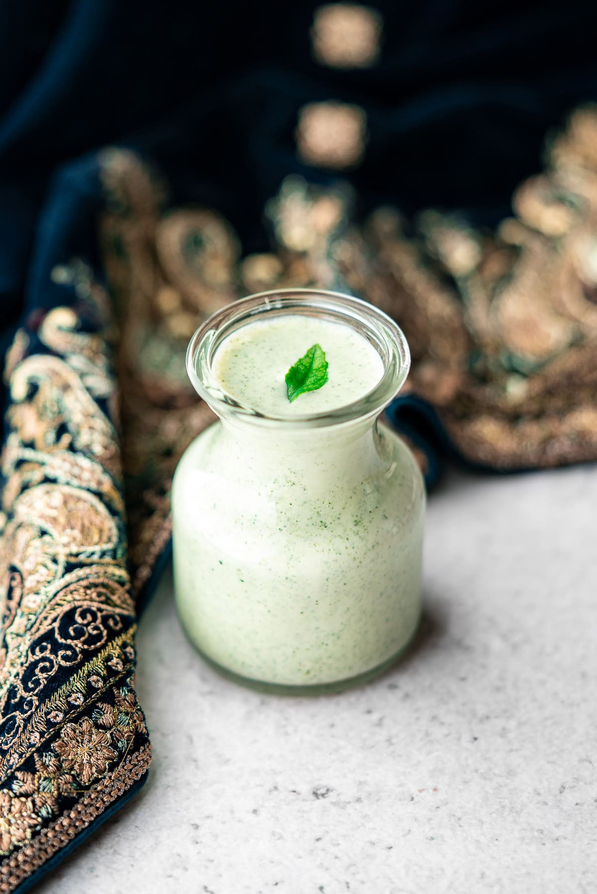 curry leaf ranch in a jar with a fresh curry leaf with a dupatta cozying into it