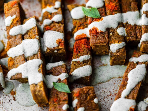 a tray full of chickpea fries drizzled in curry leaf ranch and spices