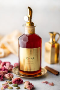 syrup bottle filled with chai syrup with a label decorated with roses and cardamom