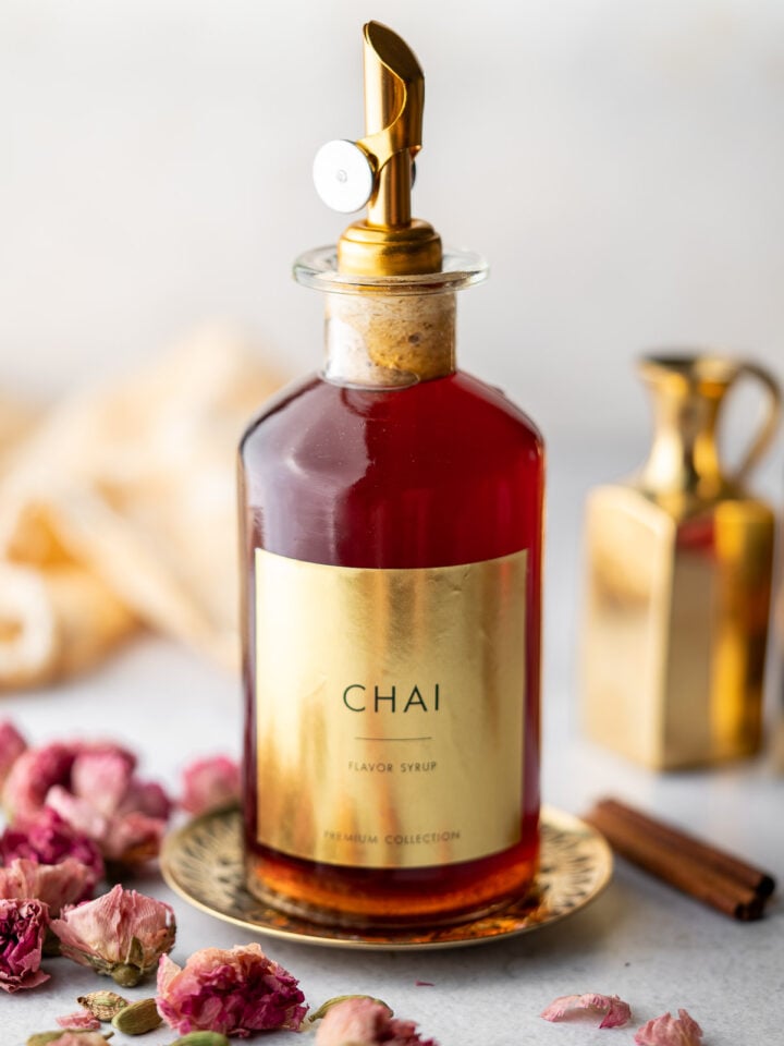 syrup bottle filled with chai syrup with a label decorated with roses and cardamom
