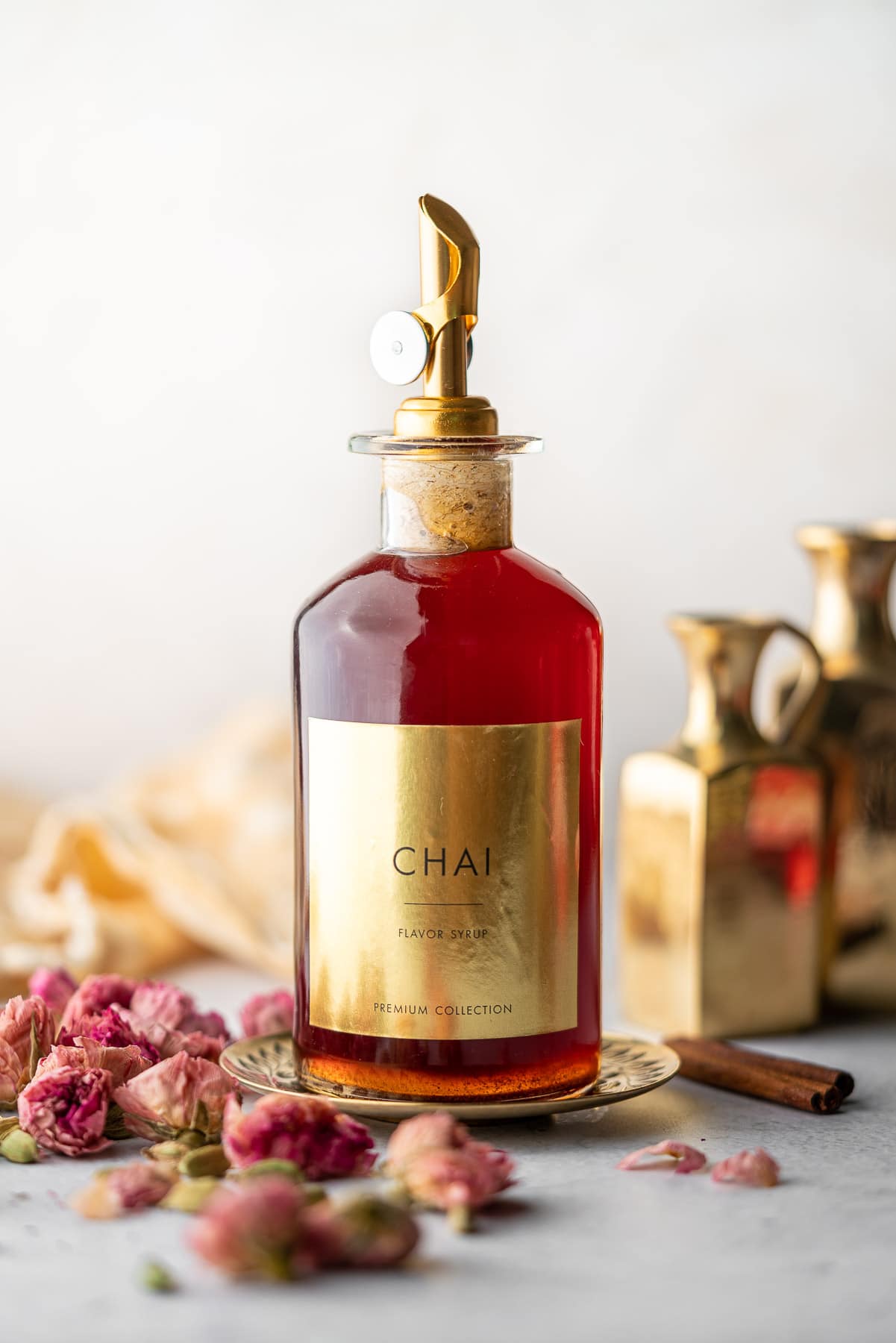 syrup bottle filled with chai syrup with a label decorated with roses and cardamom