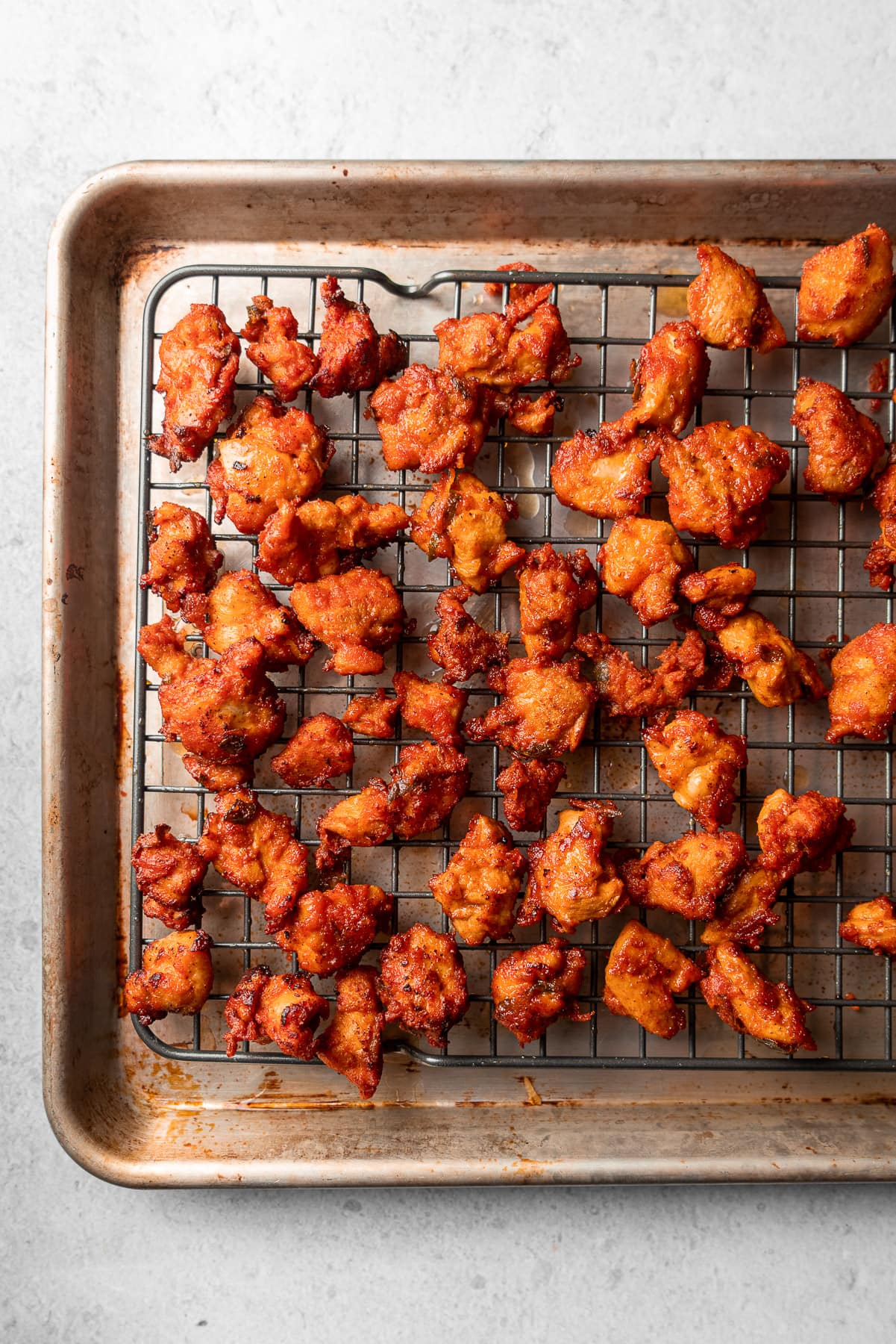 chicken 65 fried in a baking sheet on a rack