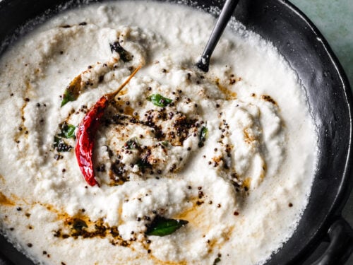 coconut chutney in a bowl with a black spoon
