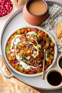 samosa chaat with in a tray with masala chai and extra samosa with chutneys