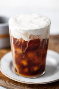 sweet cream cold foam cold brew in a glass on a plate