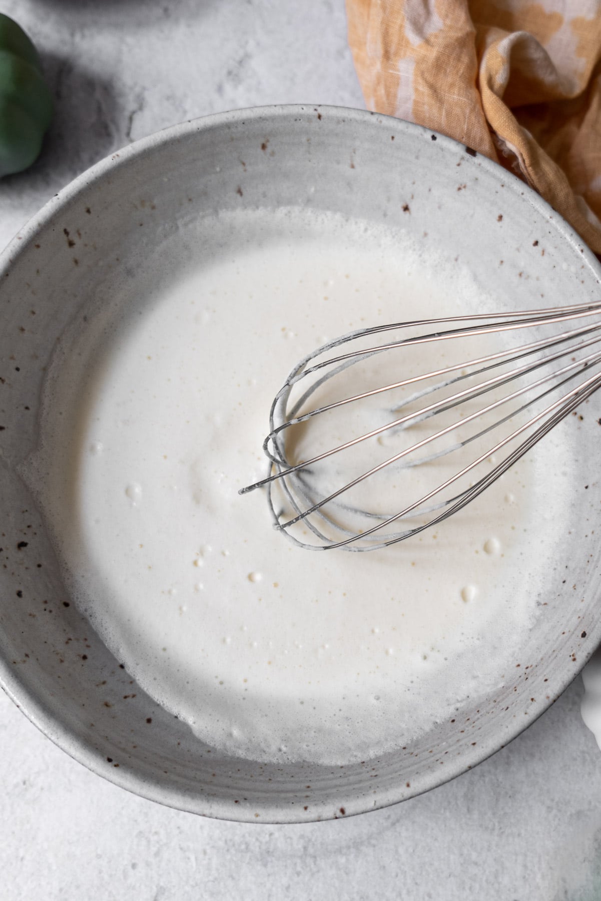 Using a whisk to whip sweet cream cold foam in a bowl