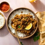whole masoor dal in a bowl with rice and a gold spoon