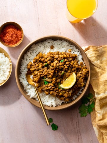 whole masoor dal in a bowl with rice and a gold spoon