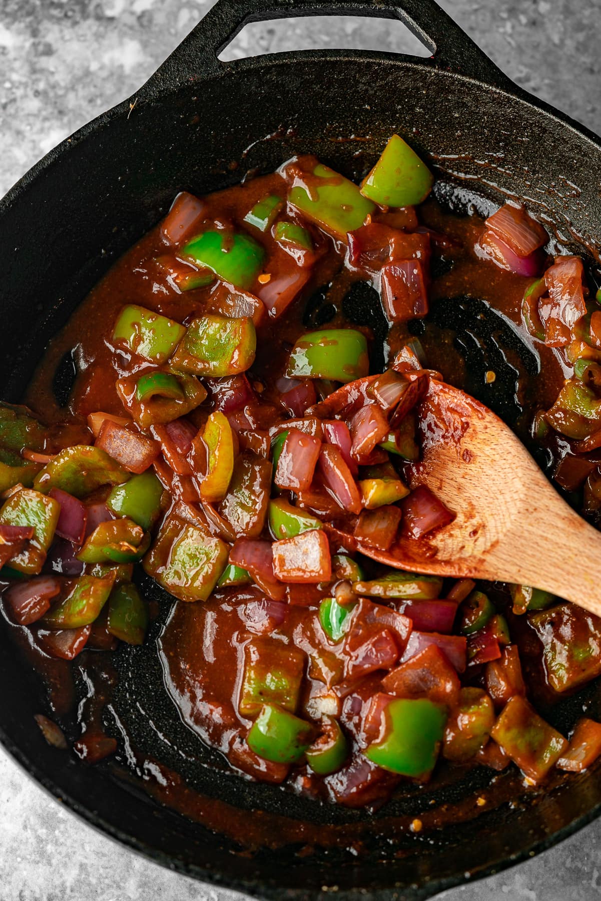 a cast iron with chili paneer sauce and vegetables